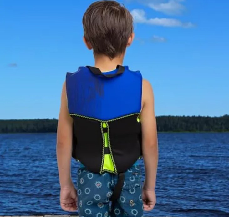 Niño con chaleco salvavidas mirando el lago